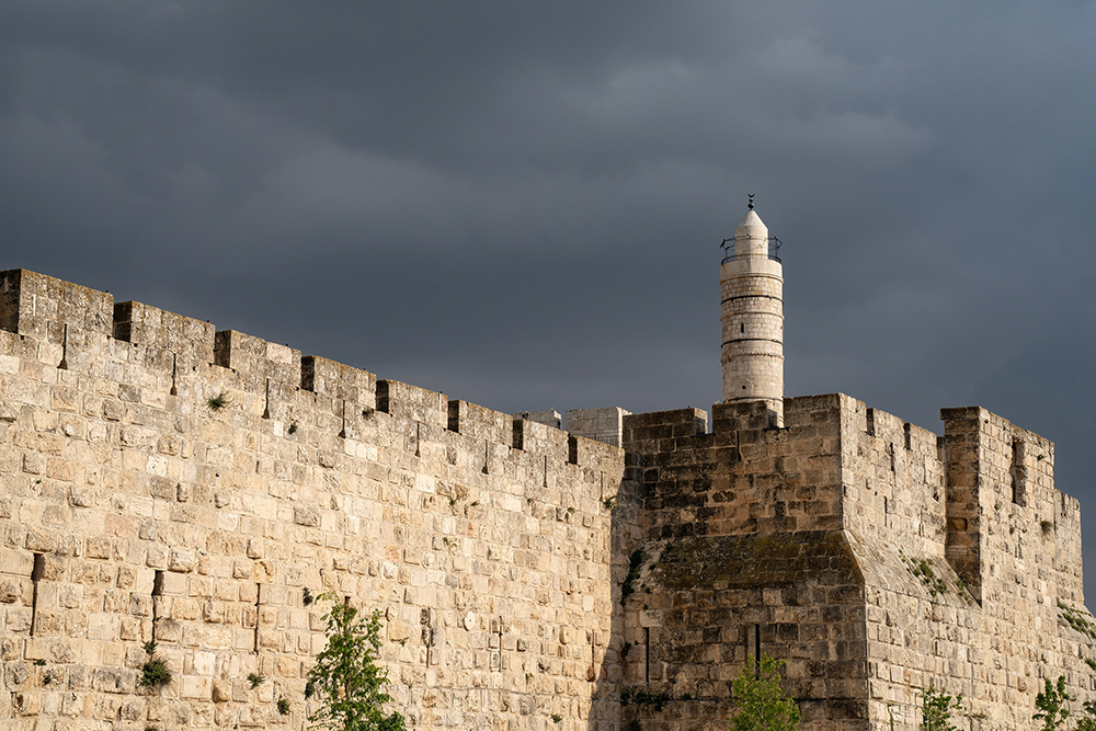 Western Wall in Jerusalem beneath dark storm clouds.